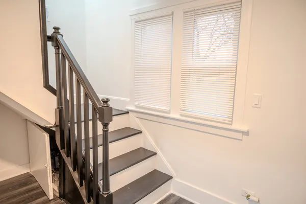a view of staircase with wooden floor and white walls
