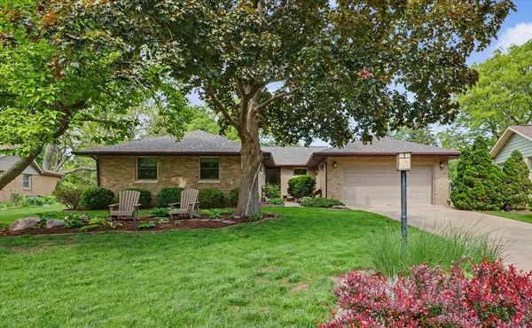 a front view of a house with a yard and trees