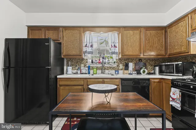 a kitchen with stainless steel appliances granite countertop a refrigerator a sink dishwasher a stove and a refrigerator