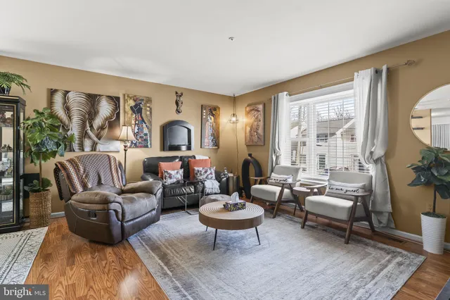 a living room with furniture potted plant and a large window