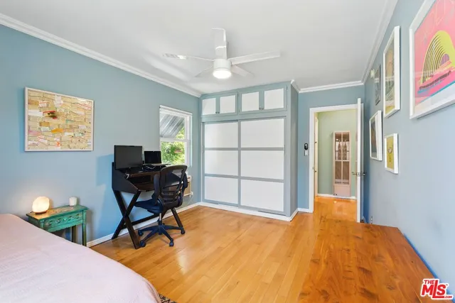 a bedroom with bed table chair and window