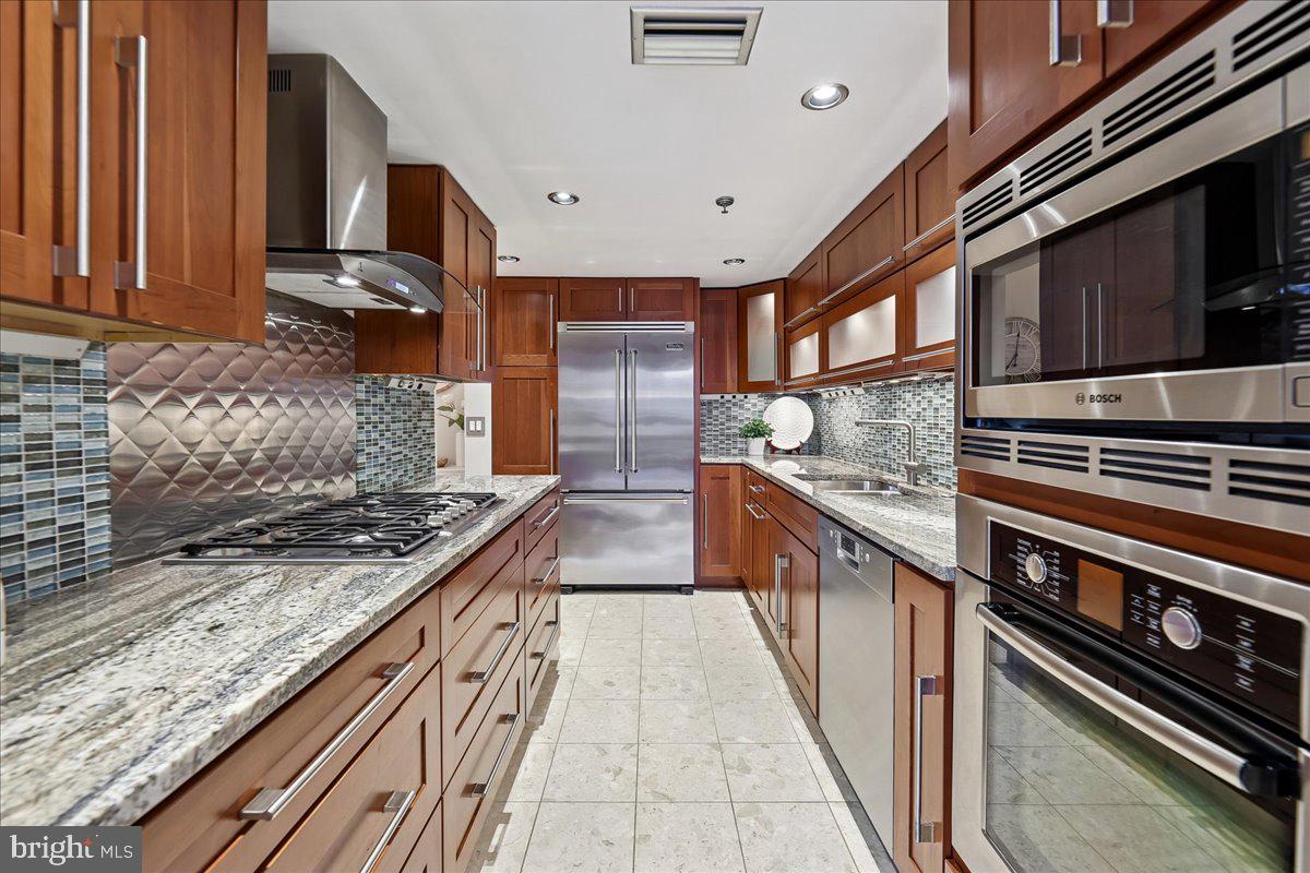 1276 North Wayne Street, Unit 418 Arlington, VA 22201 - Photo 6 of 38 a kitchen with stainless steel appliances granite countertop a stove and a sink
