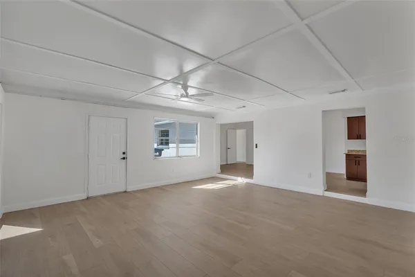 an empty room with windows and fan