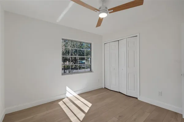 an empty room with windows and fan