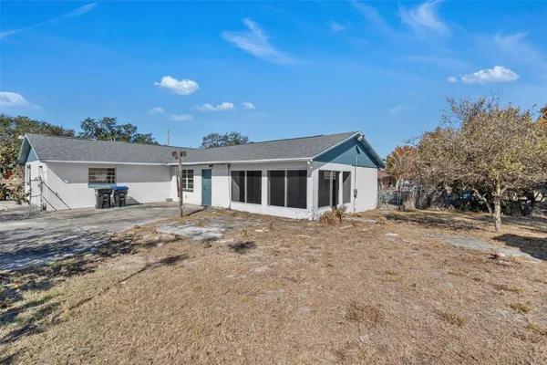 a view of a yard in front of a house with a large tree