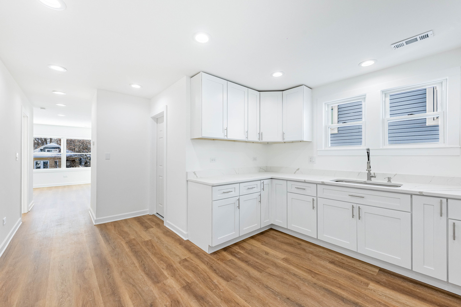1719 North Merrimac Avenue Chicago, IL 60639 - Photo 21 of 35 a kitchen with wooden floors and white cabinets