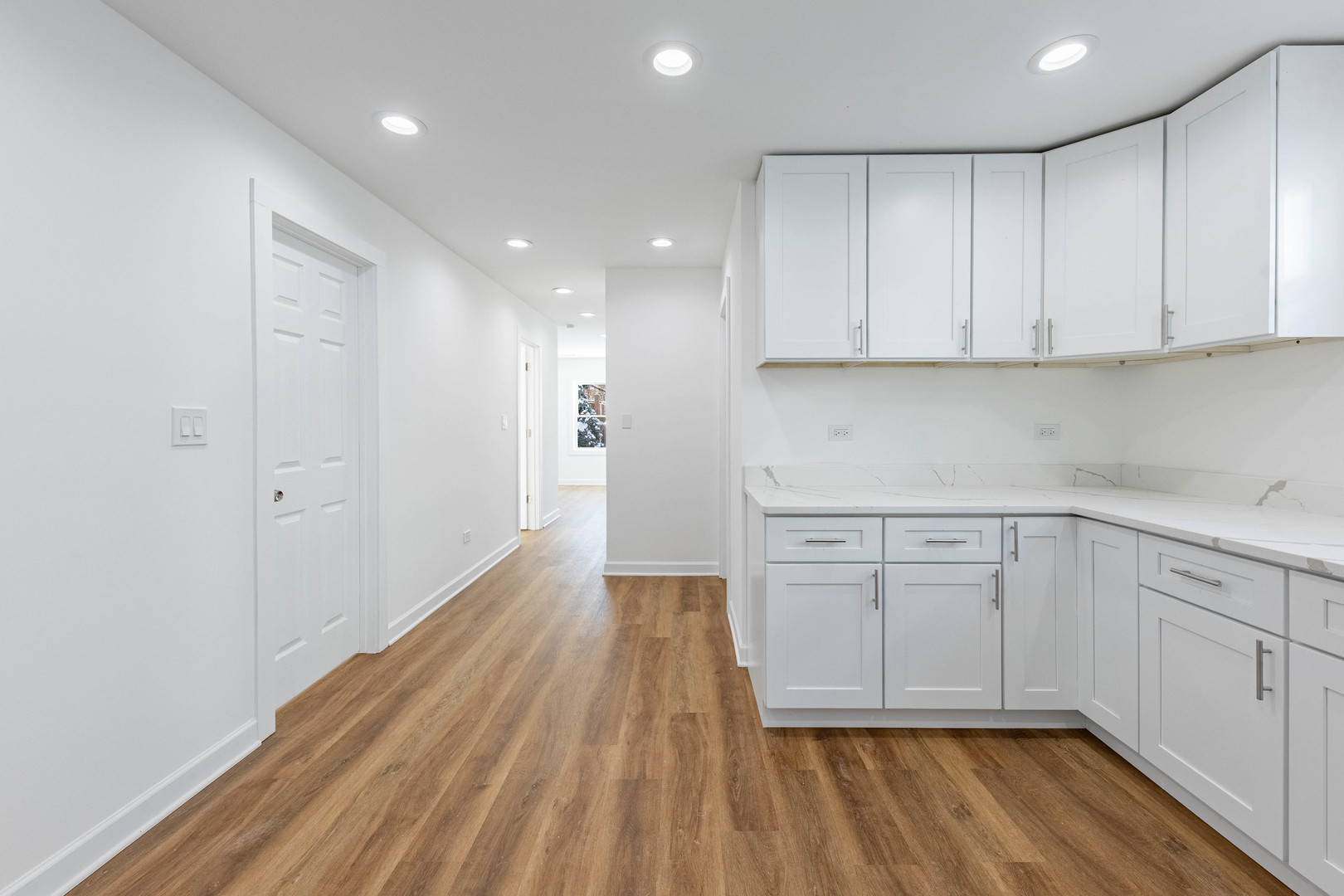 1719 North Merrimac Avenue Chicago, IL 60639 - Photo 22 of 35 a kitchen with white cabinets and wooden floor