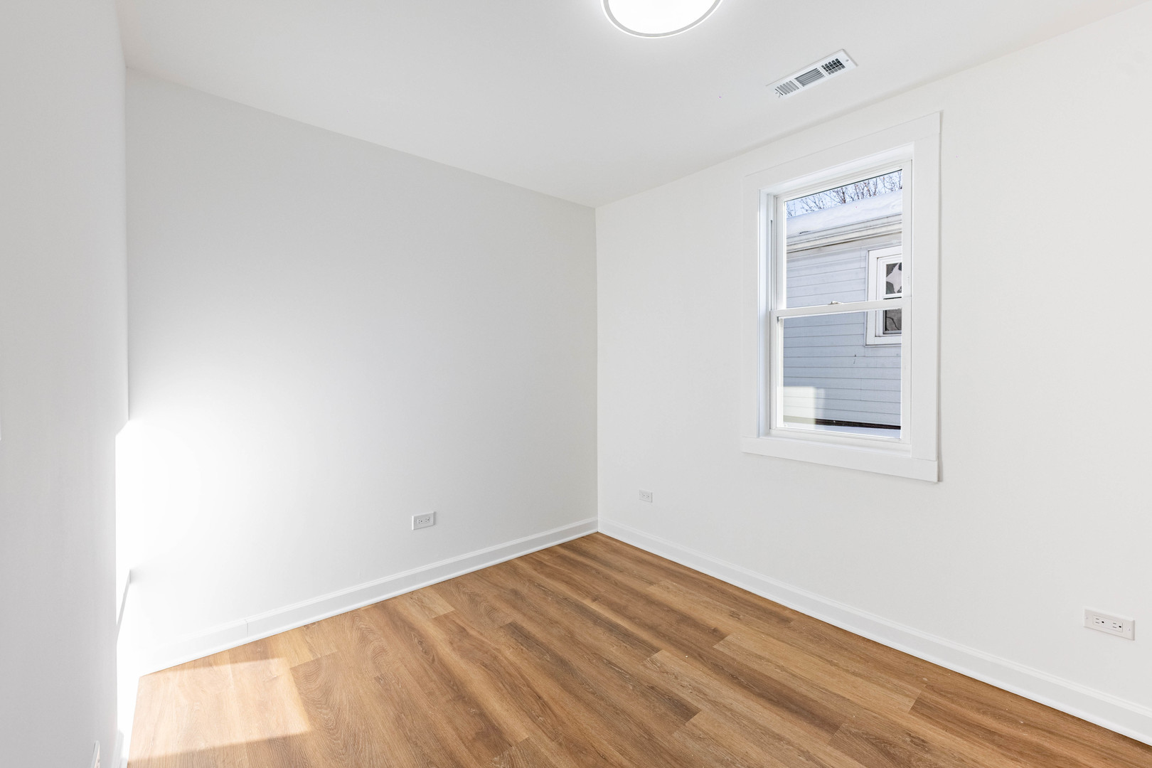 1719 North Merrimac Avenue Chicago, IL 60639 - Photo 24 of 35 a view of an empty room with wooden floor and a window