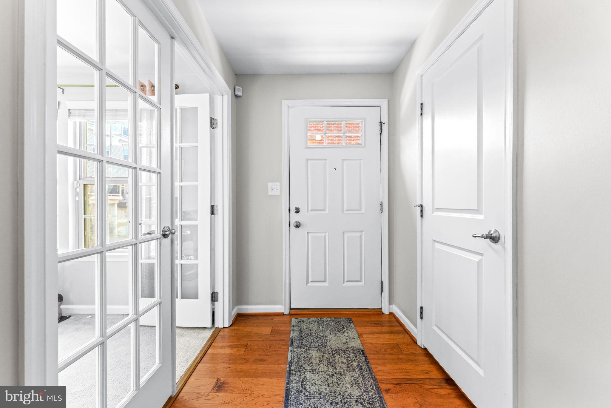 4648 Hudson Street Baltimore, MD 21224 - Photo 4 of 46 a view of a hallway with wooden floor and a bathroom