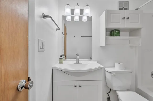 a bathroom with a sink a toilet and mirror