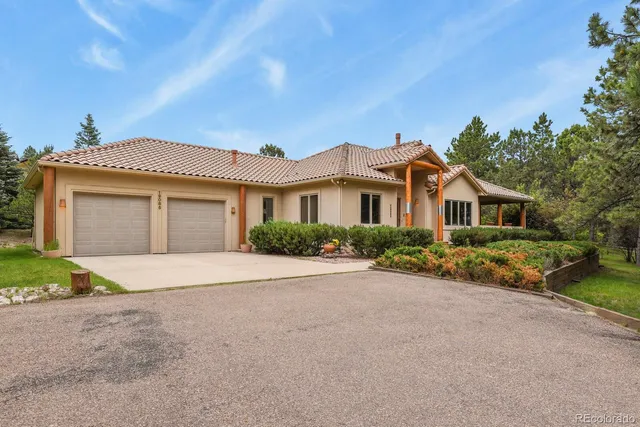 a front view of a house with a garden and yard