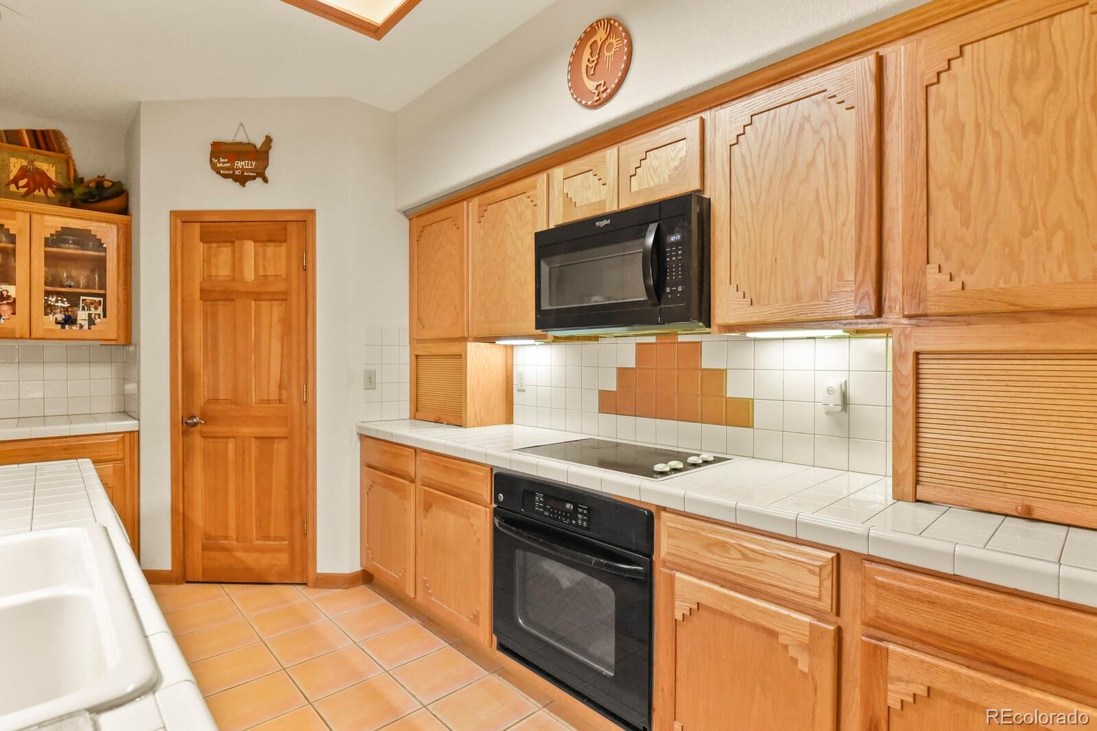 19085 Merry Men Circle Monument, CO 80132 - Photo 11 of 50 a kitchen with stainless steel appliances granite countertop a stove a sink and a microwave