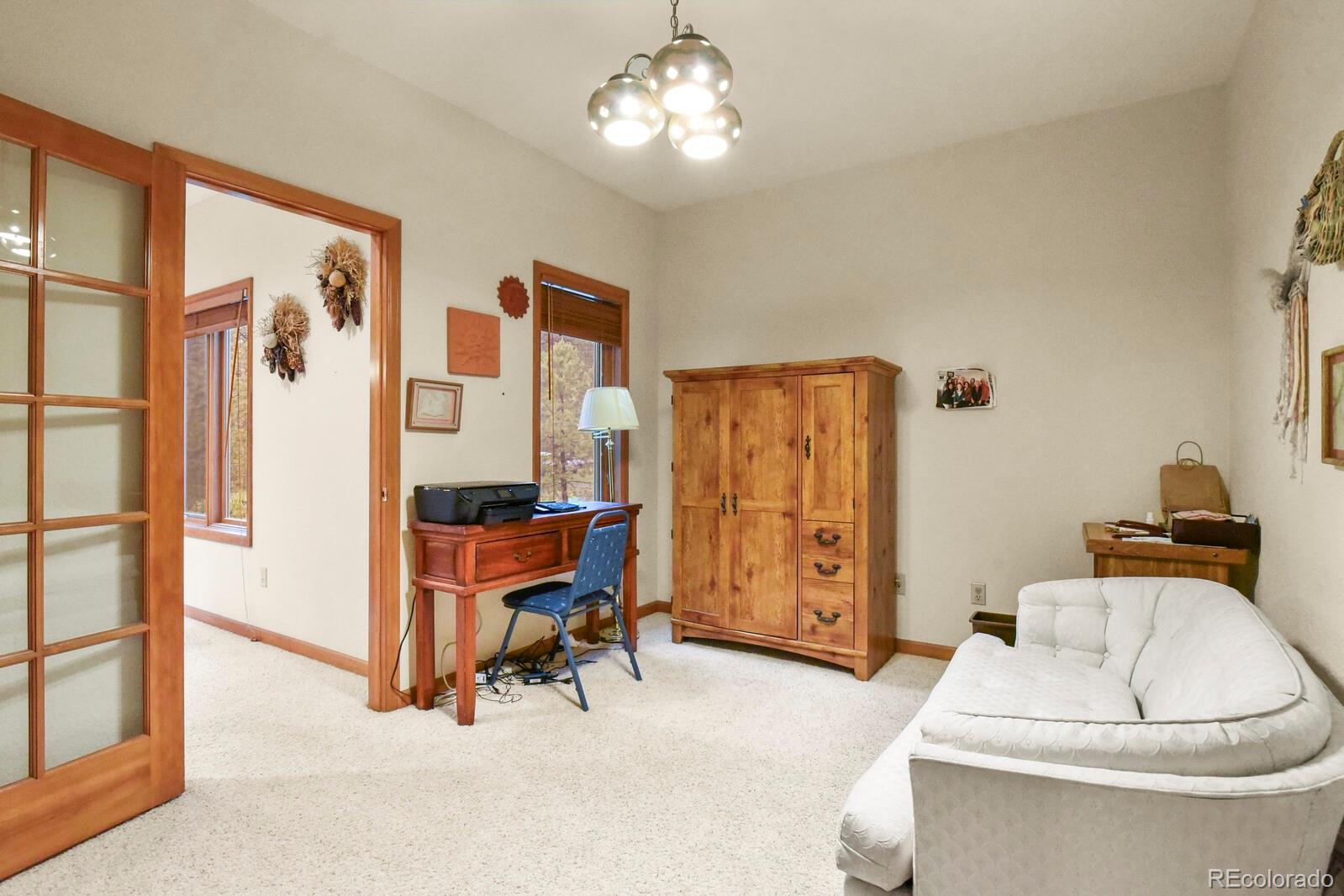 19085 Merry Men Circle Monument, CO 80132 - Photo 16 of 50 a living room with furniture a desk and chair with the view of bathroom