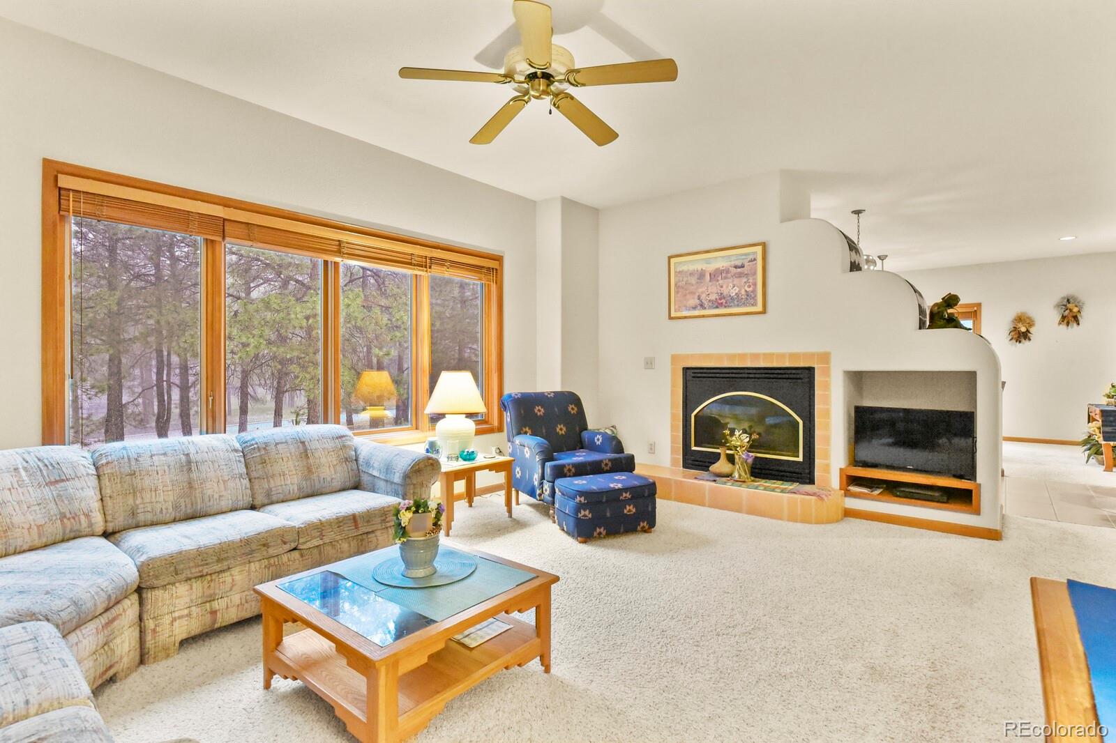 19085 Merry Men Circle Monument, CO 80132 - Photo 7 of 50 a living room with furniture a fireplace and a large window