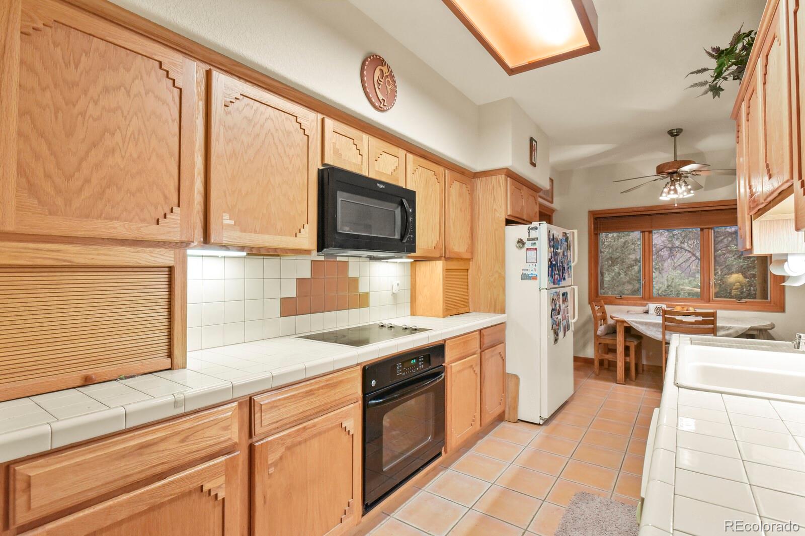 19085 Merry Men Circle Monument, CO 80132 - Photo 9 of 50 a kitchen with stainless steel appliances granite countertop a stove a sink and a microwave