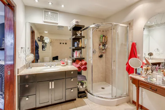 a bathroom with a sink vanity mirror and shower