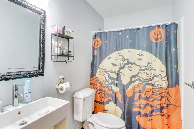 a bathroom with a sink and mirror with toilet