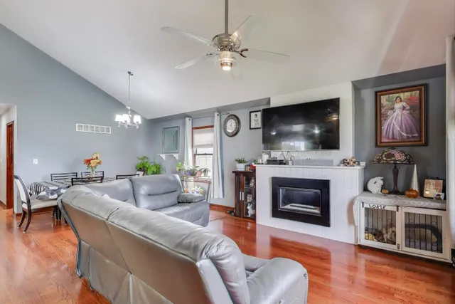 a living room with furniture a flat screen tv and a fireplace