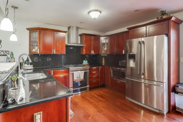 a kitchen with stainless steel appliances granite countertop a refrigerator and a sink
