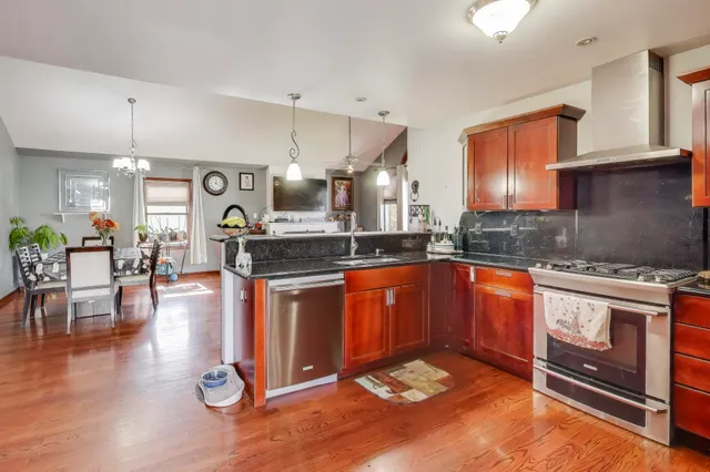 a kitchen with stainless steel appliances granite countertop a stove a sink and a wooden cabinets