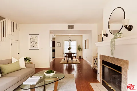 a living room with furniture a fireplace and wooden floor