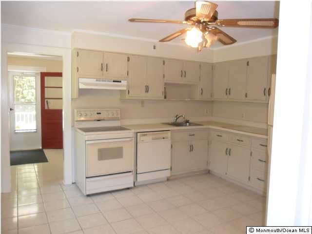 634 Fort Plains Road Howell, NJ 07731 - Photo 3 of 14 a kitchen with white cabinets and white appliances