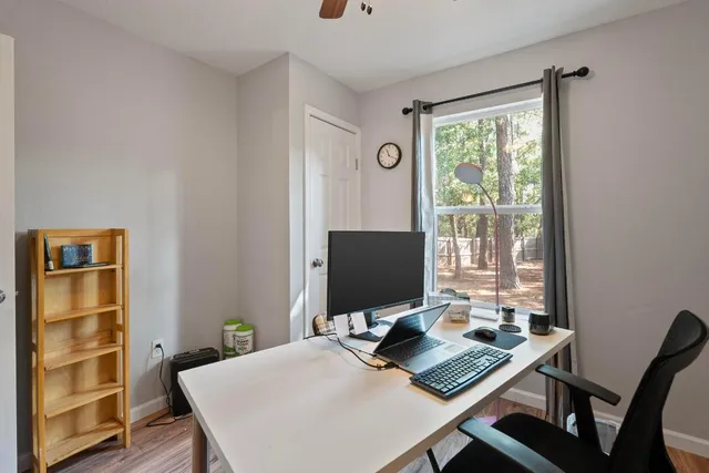 a view of a workspace with furniture and a window