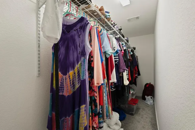 a view of walk in closet with clothes
