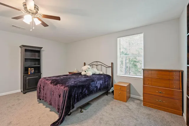 a bedroom with a bed a chandelier and a window