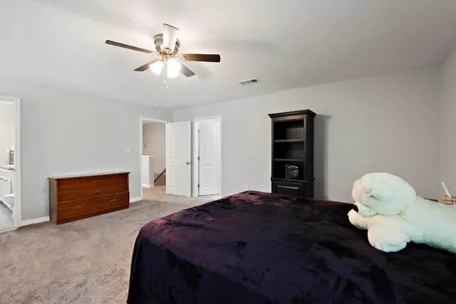 a bedroom with a bed and a ceiling fan