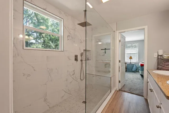 a bathroom with a glass shower door and a sink