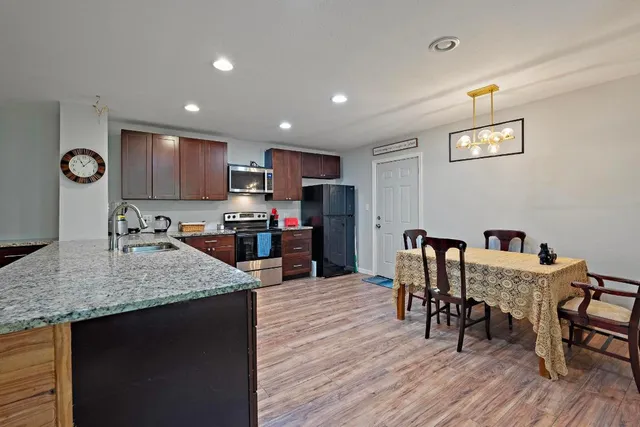 a kitchen with granite countertop kitchen island stainless steel appliances a dining table chairs and granite counter tops