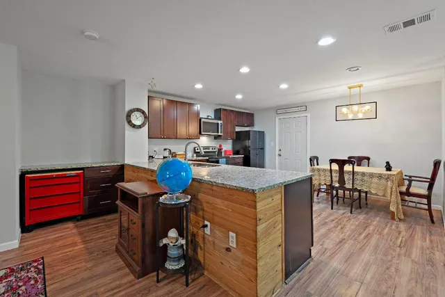a open kitchen with stainless steel appliances granite countertop a stove and a refrigerator
