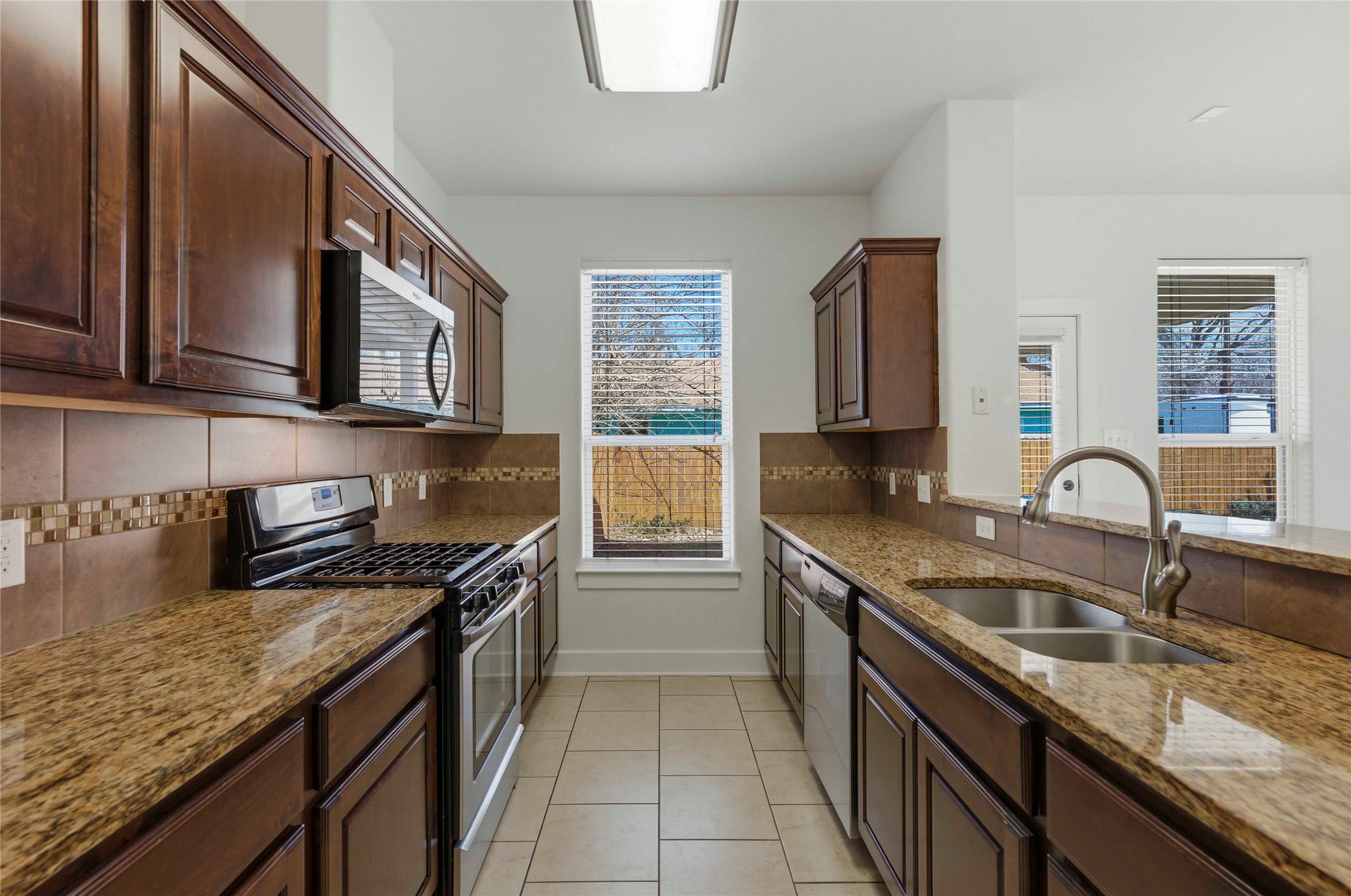 1620 Haskell Street, Unit B Austin, TX 78702 - Photo 3 of 27 a kitchen with granite countertop stainless steel appliances a sink stove and cabinets