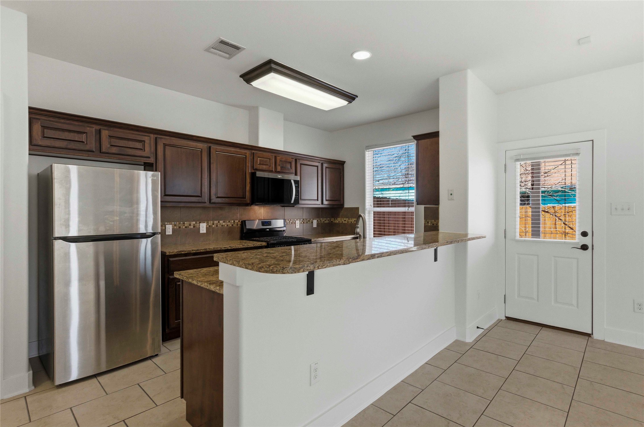 1620 Haskell Street, Unit B Austin, TX 78702 - Photo 7 of 27 a kitchen with granite countertop a refrigerator and a stove top oven