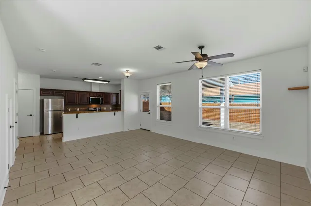 a view of wooden floor and a chandelier fan in a room