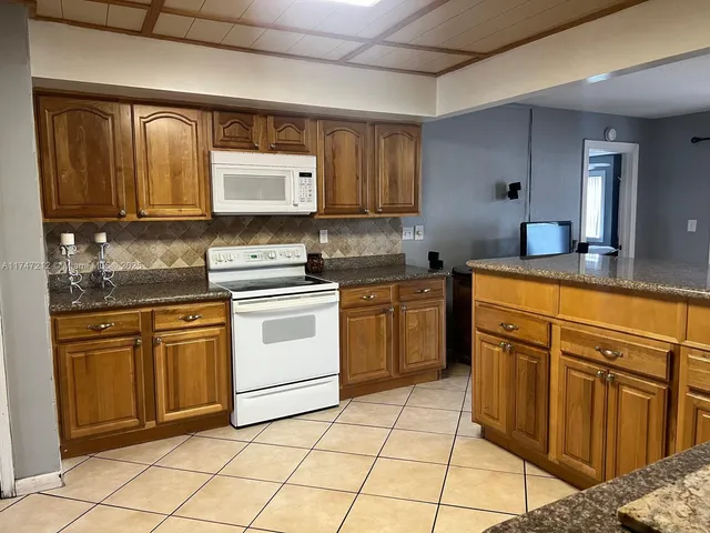 a kitchen with stainless steel appliances granite countertop a sink stove oven and cabinets