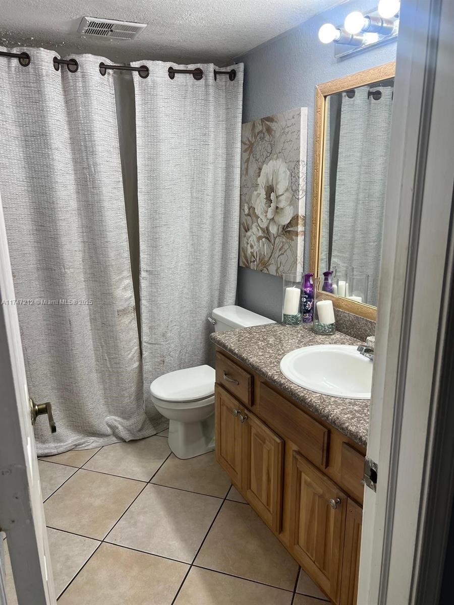 3057 Coral Springs Drive, Unit 102 Coral Springs, FL 33065 - Photo 12 of 26 a bathroom with a granite countertop sink toilet and shower