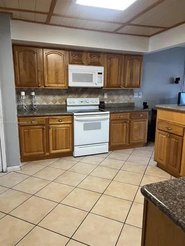 a kitchen with stainless steel appliances granite countertop a stove a sink dishwasher and a microwave oven on the granite countertops