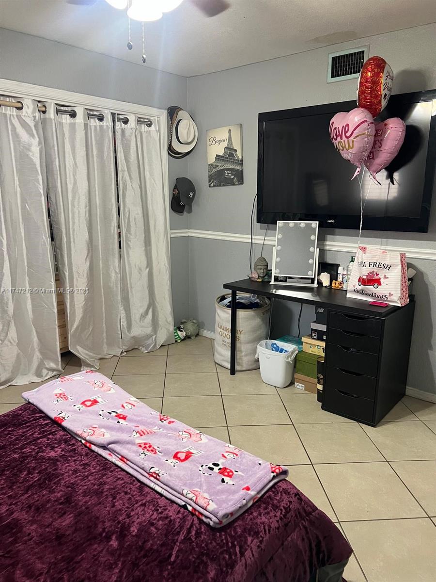 3057 Coral Springs Drive, Unit 102 Coral Springs, FL 33065 - Photo 22 of 26 a bedroom with a bed and a flat screen tv