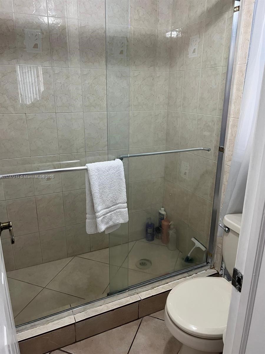 3057 Coral Springs Drive, Unit 102 Coral Springs, FL 33065 - Photo 24 of 26 a bathroom with a sink a toilet and shower