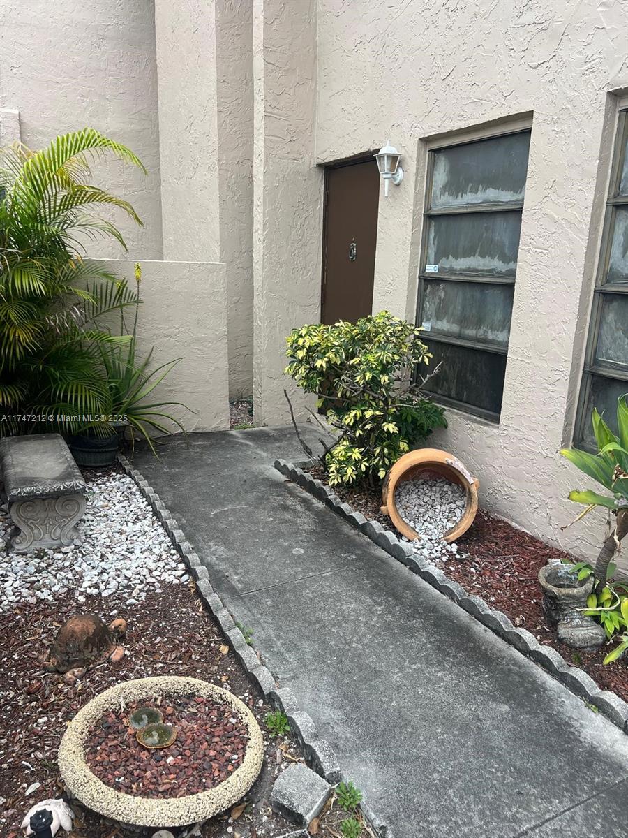 3057 Coral Springs Drive, Unit 102 Coral Springs, FL 33065 - Photo 25 of 26 a couple of potted plants sitting in front of a house