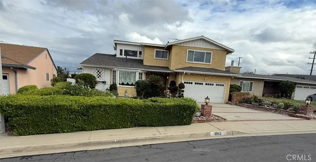 a view of a white house next to a yard
