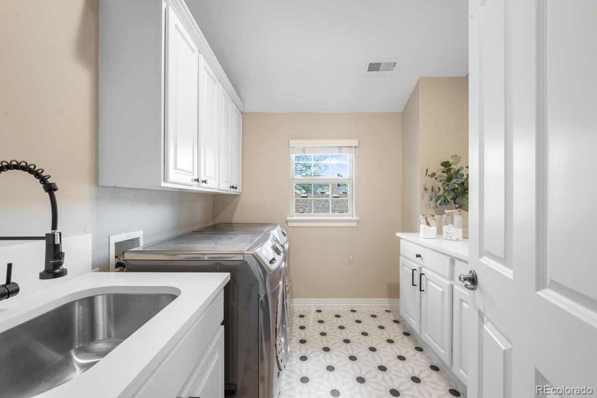 1214 South Fillmore Street Denver, CO 80210 - Photo 42 of 50 a kitchen with stainless steel appliances a sink a refrigerator a counter space and a window