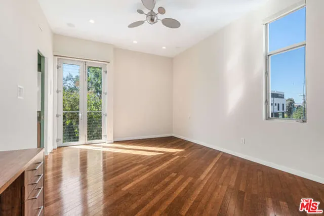 an empty room with wooden floor and entrance