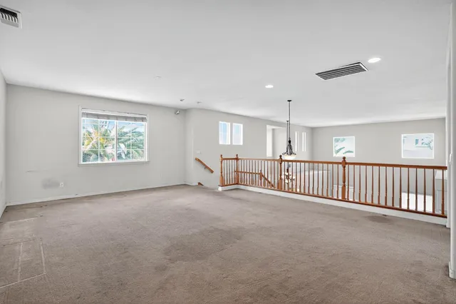 an empty room with windows and brick walls