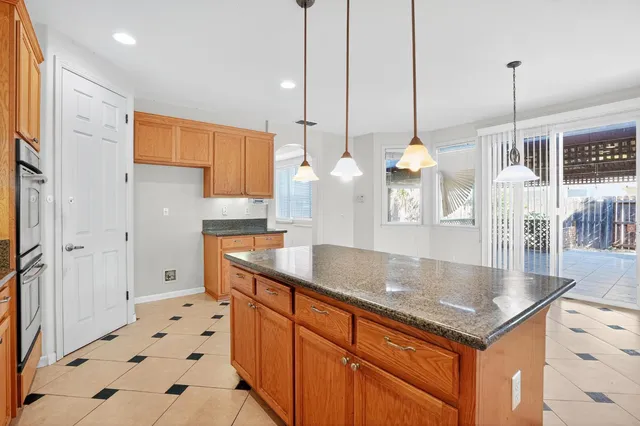 a kitchen with stainless steel appliances granite countertop a sink a refrigerator and a counter top space