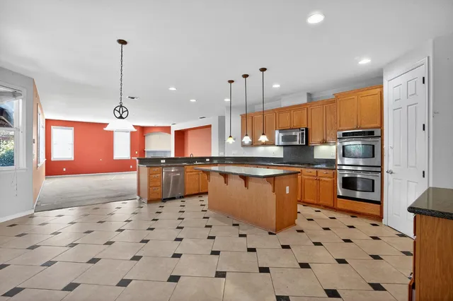 a kitchen with stainless steel appliances a refrigerator sink and microwave