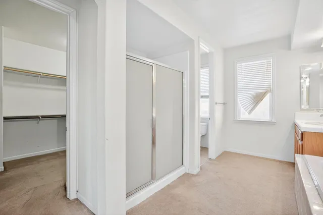 a view of an empty room with window and closet area