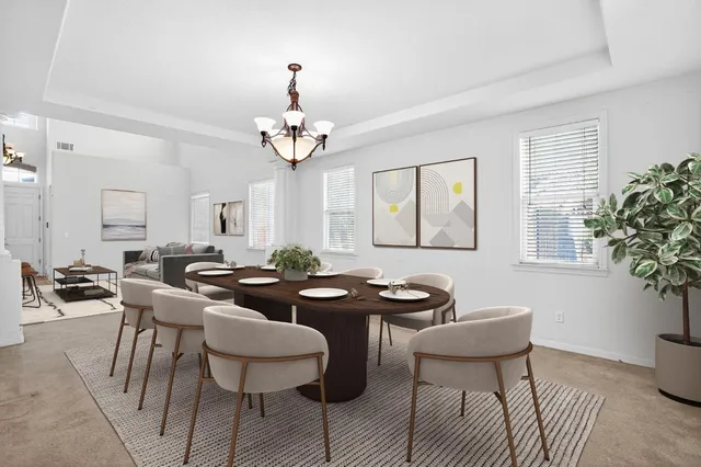a view of a dining room with furniture and chandelier